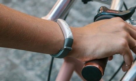 Handled med träningsarmband på cykelstyre under träning